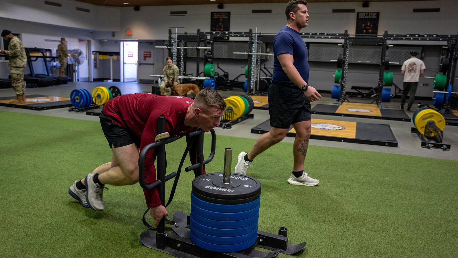 Competitor pushing a weighted sled during a HYROX fitness competition